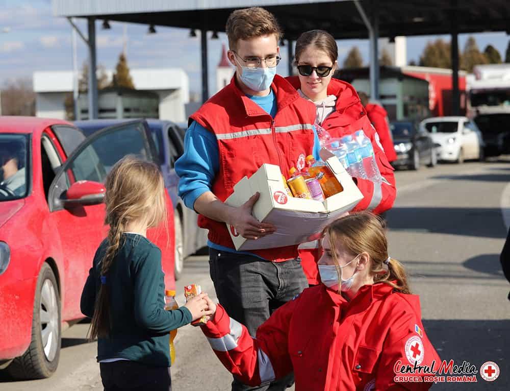 Punaisen Ristin vapaaehtoiset antavat ruokaa ja vettä Ukrainasta saapuville ihmisille Petean rajanylitysasemalla Romaniassa. Kuva: Romanian Punainen Risti.